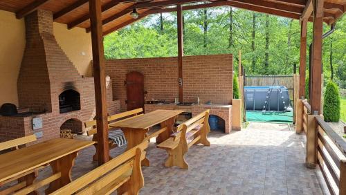 un patio con bancos de madera y una chimenea de ladrillo en Pensiunea Inima Daciei en Costeşti