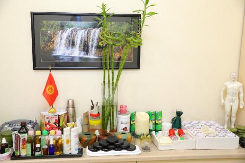 a table with a vase of flowers and other items at Park Hotel Bishkek in Bishkek