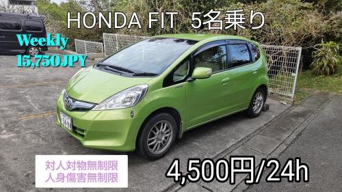 a green smart car parked in a parking lot at Holiday House Ryukyu-an "MUSIC HOSTEL" in Yomitan