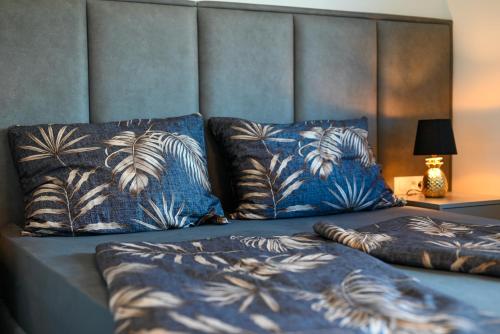 un letto con due cuscini blu sopra di Penthouse Bluesky a Okrug Gornji
