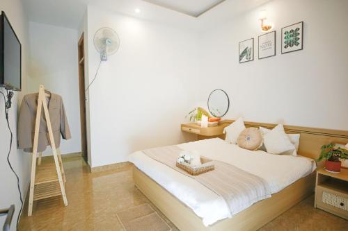 a bedroom with a bed and a floor fan at Huong Anh DaLat Palace in Da Lat