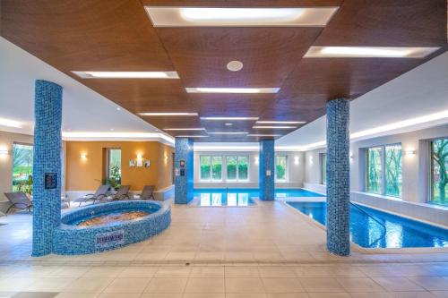 a swimming pool in a hotel lobby with a swimming pool at Royal Club Hotel in Visegrád