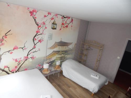 - une chambre avec un lit et un mur orné d'un cerisier dans l'établissement Hotel Angelys, à Ploërmel