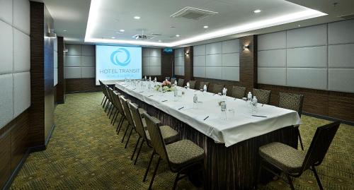 a long table in a room with chairs and a screen at Hotel Transit Kuala Lumpur in Kuala Lumpur