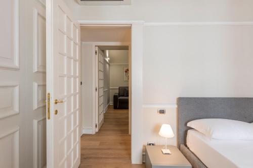 a bedroom with a bed and a door leading to a hallway at Milan Royal Suites - Centro in Milan