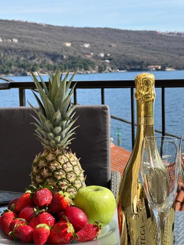 einen Tisch mit Obst und eine Flasche Champagner in der Unterkunft Villa Volos apartment Karmen with roof terrace, sea view, free private parking in Opatija
