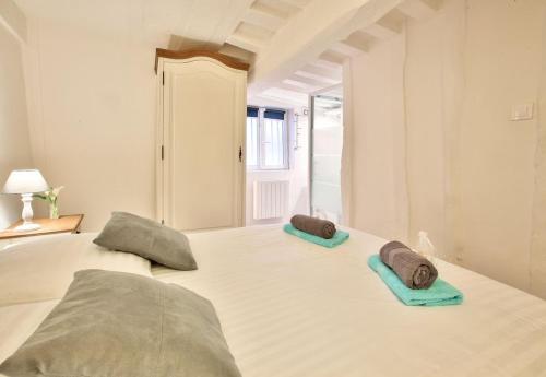 un lit blanc avec deux oreillers dessus dans l'établissement L Hibiscus 1, à Rouen