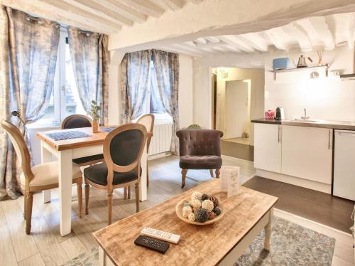 une cuisine et un salon avec une table et des chaises dans l'établissement L Hibiscus 1, à Rouen