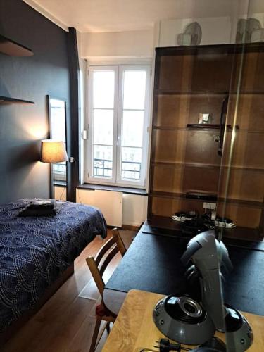 une chambre avec un lit et une table avec un aspirateur dans l'établissement Studette Place Jamot, à Reims