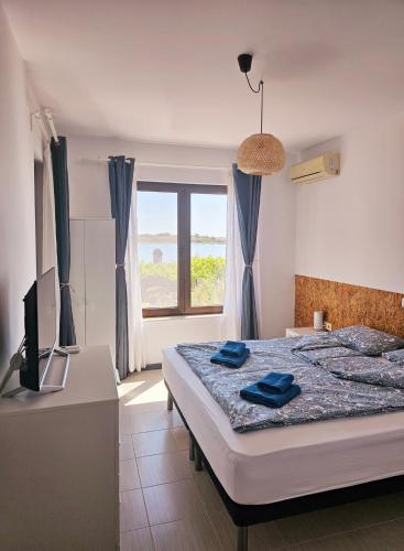 a bedroom with a bed and a television and a window at Sea Vacation Homes in Chernomorets