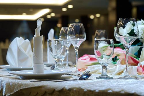 a table with wine glasses and plates on it at Hotel Transit Kuala Lumpur in Kuala Lumpur