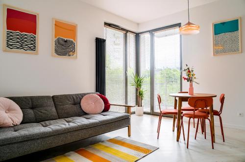 - un salon avec un canapé et une table dans l'établissement CITYSTAY Garden Gates Apartment, à Gdańsk