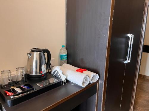 a shelf with a coffee maker and towels on a refrigerator at JB Residency !! Top Rated & Most Awarded Property in Tricity !! in Chandīgarh