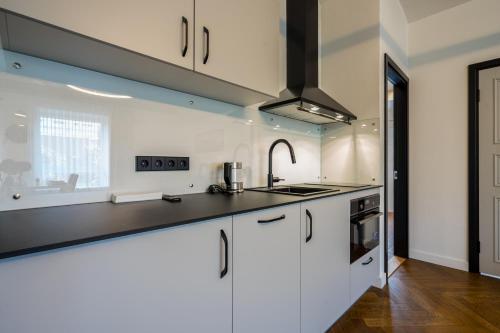 a kitchen with white cabinets and a sink at Elias Apartments in Pärnu
