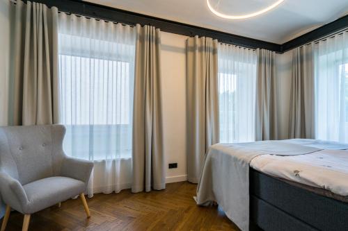 a bedroom with a bed and a chair and a window at Elias Apartments in Pärnu