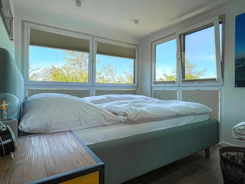 Prima Resort Boddenblick - Camping & Tiny House-Resort في Groß Kordshagen: غرفة نوم بسرير من نافذتين وطاولة