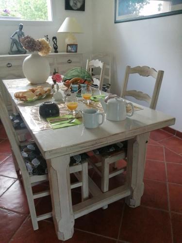 - une table avec de la nourriture et des boissons et un vase dans l'établissement zénitude, à Saint-Ouen-du-Mesnil-Oger