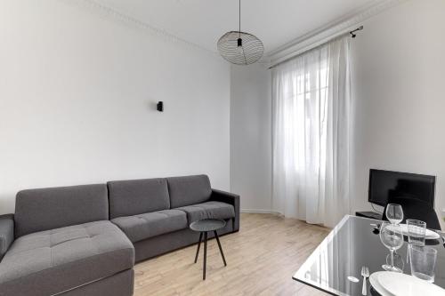 un salon avec un canapé et une télévision dans l'établissement 570 Suite Bloom - Superbe Appartement à Paris, à Paris