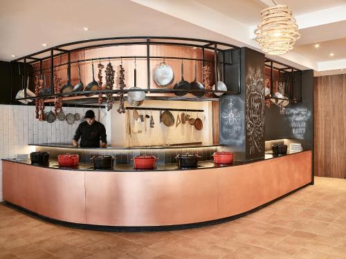 un hombre parado detrás de un mostrador en una cocina en Grecotel Casa Marron, en Kalamákion