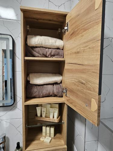 a wooden cabinet in a bathroom with towels at Sea view luxury appartment-parking in Varna City
