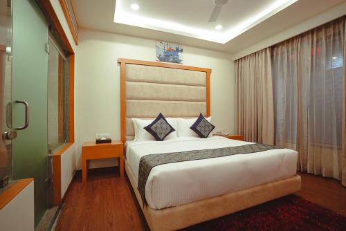 a bedroom with a large bed in a room at Ramee The Srinivas Palace in Bhuj