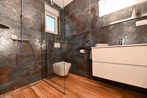 un bagno con doccia, WC e lavandino di Penthouse Bluesky a Okrug Gornji