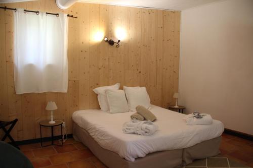 a bedroom with a bed with towels on it at Clos Saint-Michel Resort & Spa in Malaucène