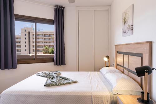 um quarto com uma cama branca e uma janela em Oceanfront 2 bedrooms Holiday Home in Tenerife South em San Miguel de Abona