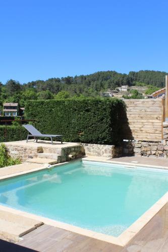 - une grande piscine dans une cour avec une chaise dans l'établissement Gîte Le Fortin, à Ucel