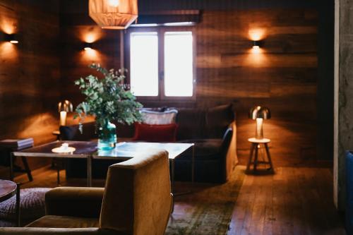 a living room with a table and chairs and a window at L´Ovella Negra Mountain Lodge in Canillo