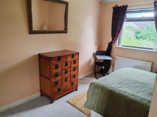 een slaapkamer met een dressoir en een spiegel bij Wallace View - Holiday Home in Stirling
