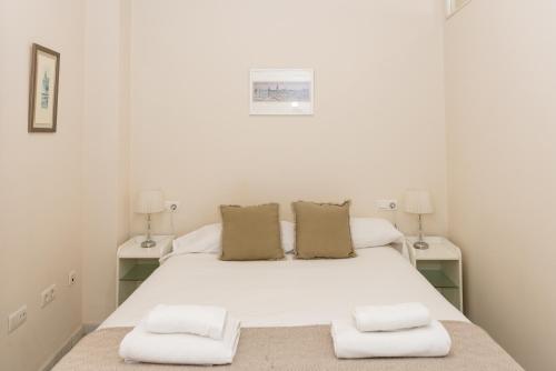 1 dormitorio con 1 cama blanca grande y 2 mesitas de noche en Charming & quiet apartment in Plaza del Salvador, en Sevilla