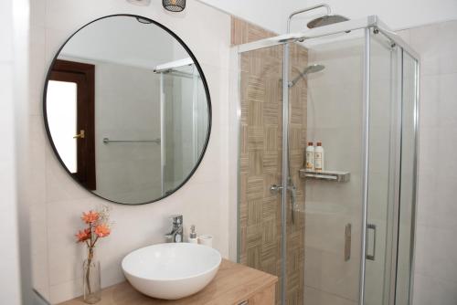 y baño con lavabo y ducha con espejo. en Charming & quiet apartment in Plaza del Salvador, en Sevilla