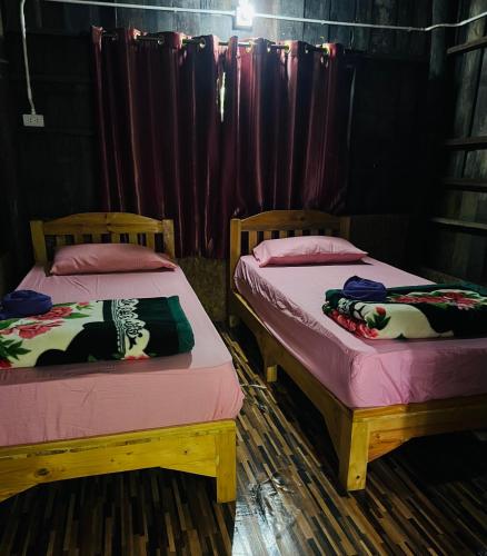 two beds sitting next to each other in a room at บ้านระเบียงน้ำ แม่แมะ in Chiang Dao