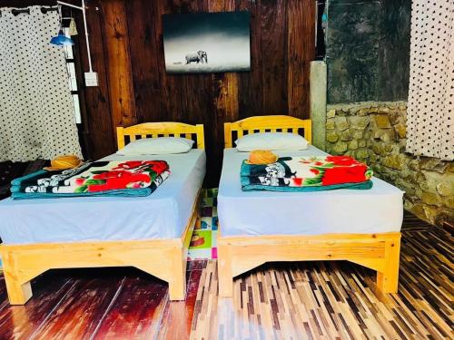 two beds sitting next to each other in a room at บ้านระเบียงน้ำ แม่แมะ in Chiang Dao