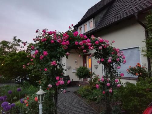 un arco con fiori rosa su una casa di Willy und Gudrun a Rheda-Wiedenbrück