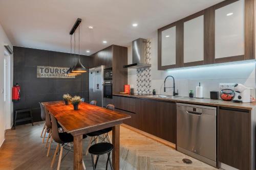 a kitchen with a wooden table and a sink at Onofre Setúbal House in Setúbal