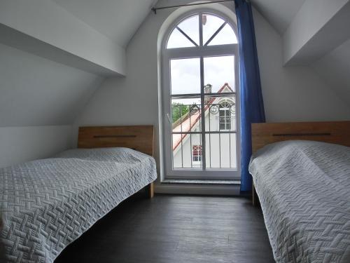 a bedroom with two beds and a large window at Ferienhaus FH T 1d in Graal-Müritz