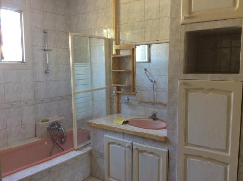 La salle de bains est pourvue d'un lavabo rose et d'une baignoire. dans l'établissement La fourmi, à Cannes