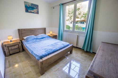 une chambre avec un lit en bois et une fenêtre dans l'établissement La fourmi, à Cannes