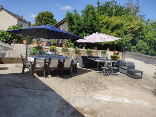 un patio avec des tables, des chaises et des parasols dans l'établissement An umbrella, à Bourges