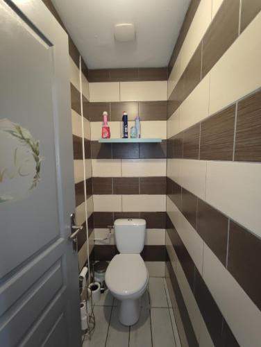 une salle de bain avec toilettes et rayures marron et blanches dans l'établissement An umbrella, à Bourges