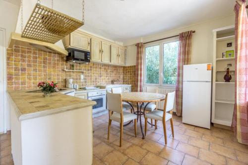 une cuisine avec une table et un réfrigérateur blanc dans l'établissement La fourmi, à Cannes