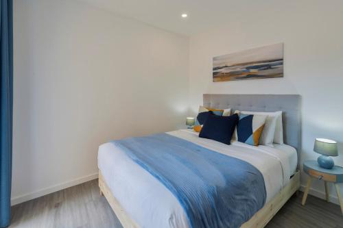 a bedroom with a large bed with blue and yellow pillows at Onofre Setúbal House in Setúbal