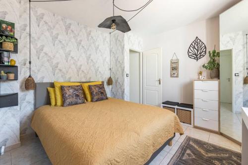 une chambre avec un lit avec des oreillers jaunes dans l'établissement l'antre deux, à Villeneuve-lès-Maguelone