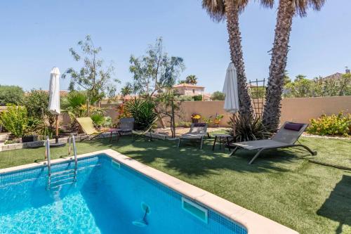 une cour avec une piscine et des palmiers dans l'établissement l'antre deux, à Villeneuve-lès-Maguelone