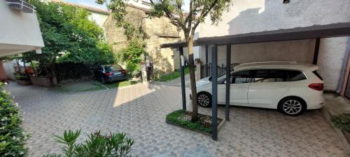 a small white car parked under a garage at Apartma Mimi in Dekani