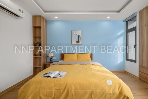 a bedroom with a yellow bed with a yellow bedspread at NNP Apartment Beach. in Da Nang