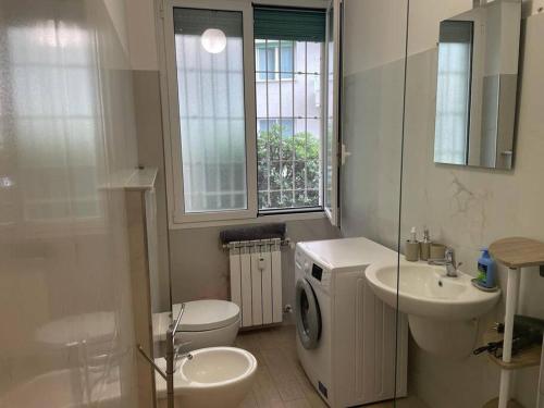 a bathroom with a toilet a sink and a washing machine at Casa Del Lupo in Genova