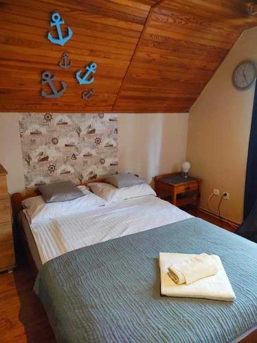 a bedroom with a bed with a towel on it at Pokoje Sowa Domek Sowa in Mikołajki